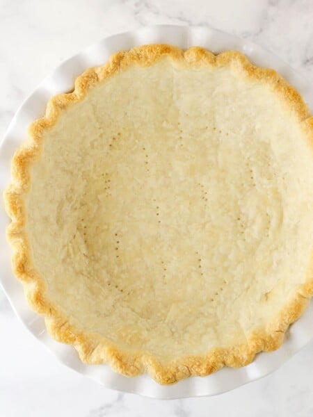 Overhead view of a fully baked pie crust in a white pie plate.