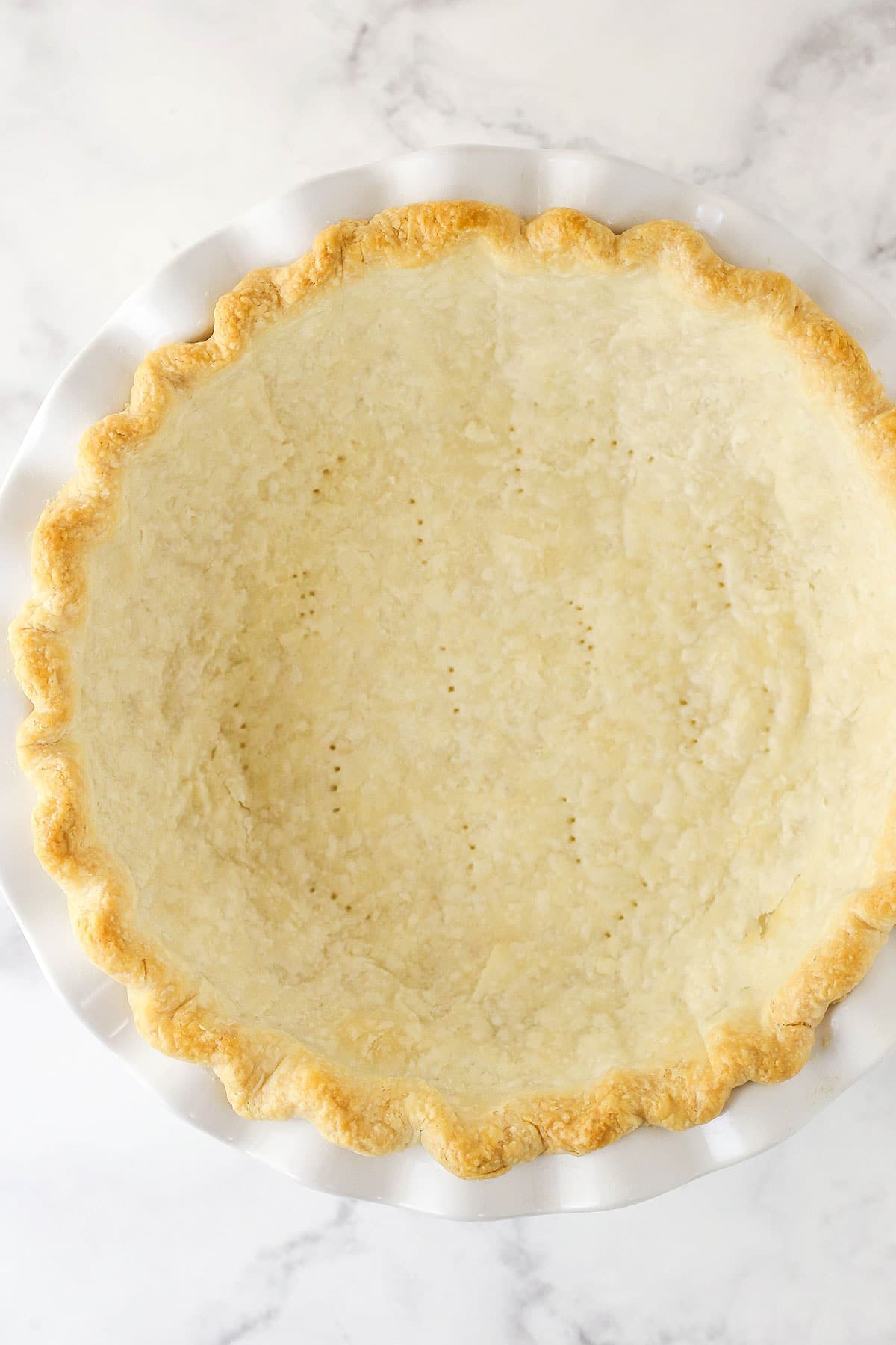 fully baked pie crust in white pie plate