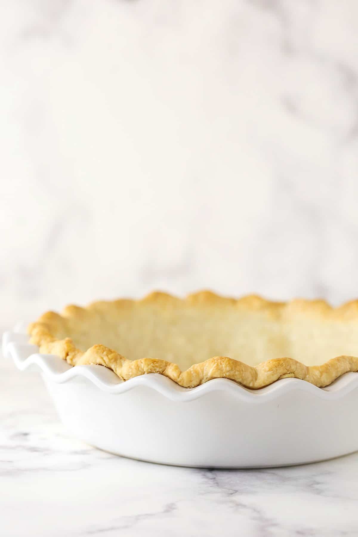blind baked pie crust in white pie plate