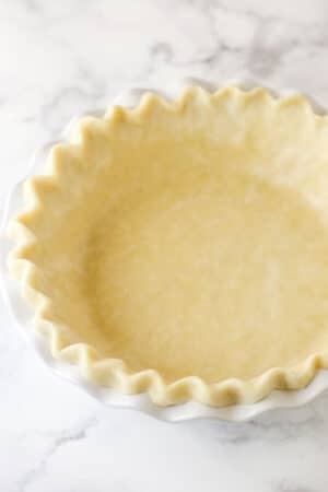 unbaked pie crust in white pie plate