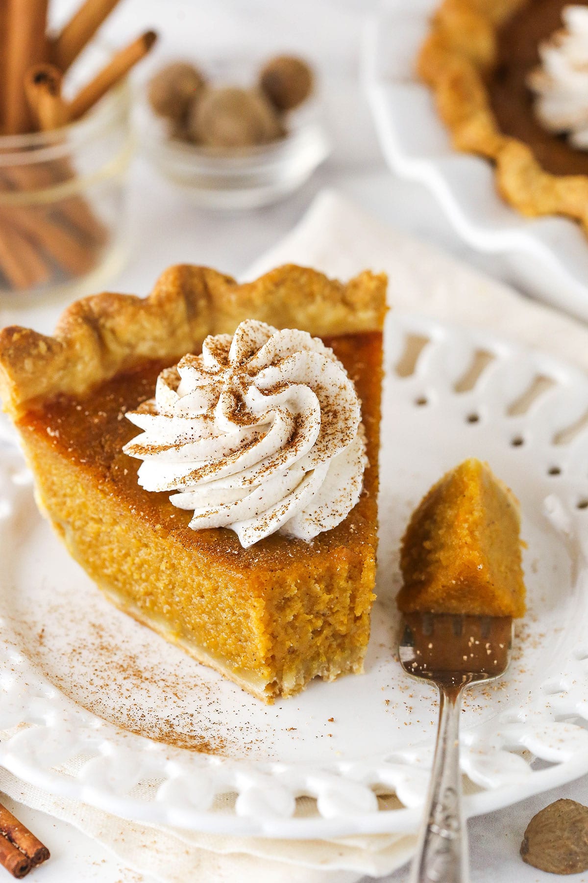 slice of sweet potato pie on white plate with a bite taken