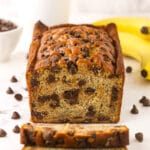 A loaf of banana bread with two freshly cut slices in front of it
