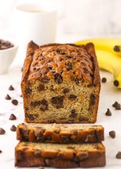 A loaf of banana bread with two freshly cut slices in front of it