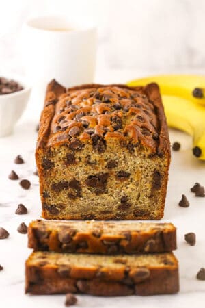 A loaf of banana bread with two freshly cut slices in front of it