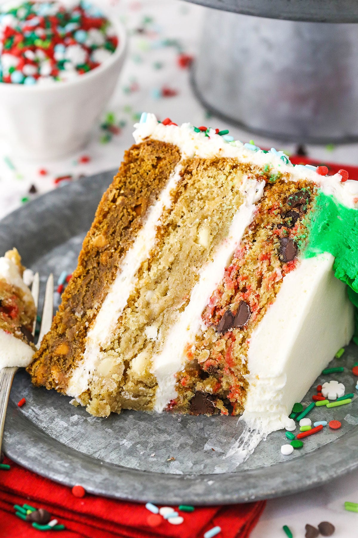 Christmas Cookie Layer Cake slice on metal plate with bite taken