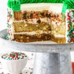 Christmas Cookie Layer Cake on metal cake stand with slices cut out to show inside layers