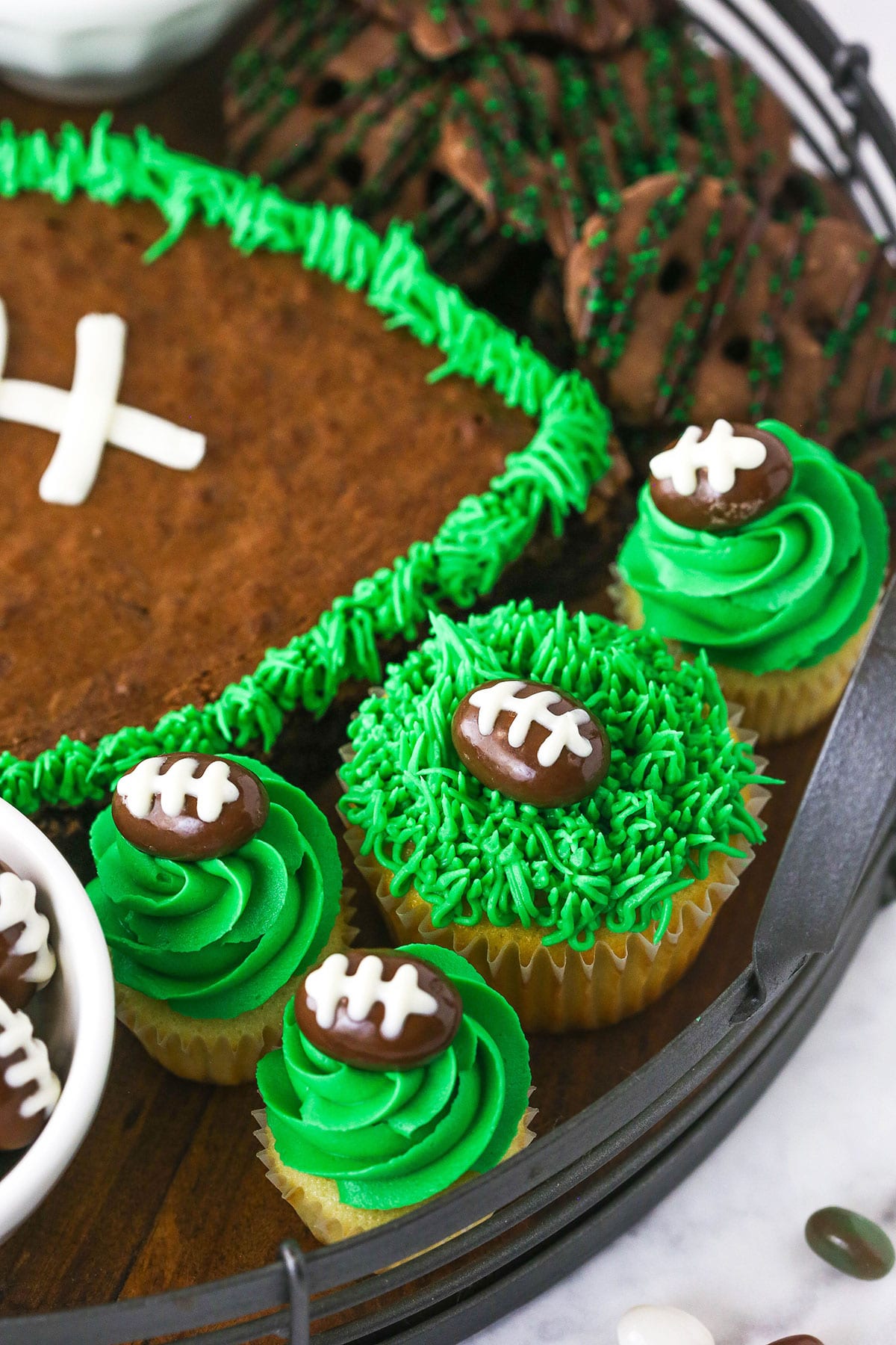 cupcakes with green buttercream piping and almond footballs on top
