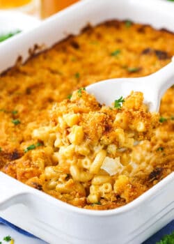 smokey beer macaroni and cheese in white casserole dish with a scoop being removed