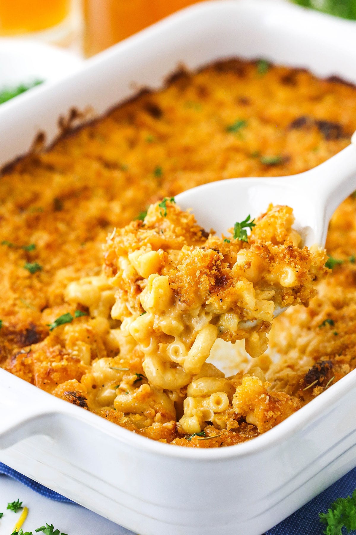 smokey beer macaroni and cheese in white casserole dish with a scoop being removed