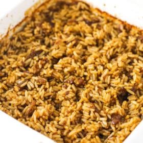 A batch of baked butter rice inside of a square baking dish