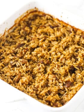 A batch of baked butter rice inside of a square baking dish