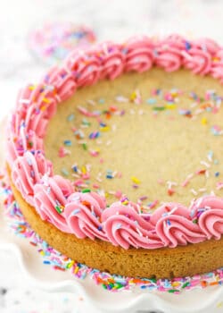 Overhead shot of a sugar cookie cake with frosting and sprinkles.