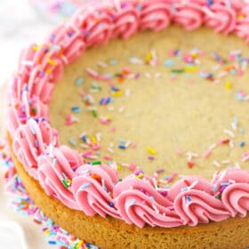 Overhead shot of a sugar cookie cake with frosting and sprinkles.