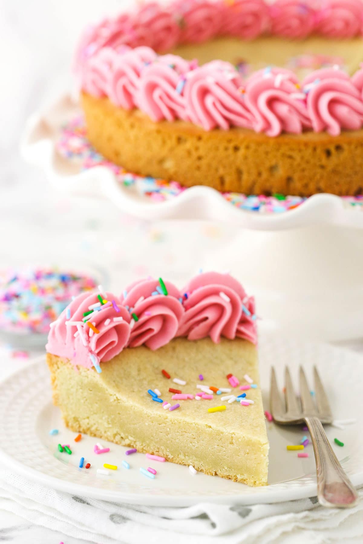 A small slice of cake on a white plate, with a fork.