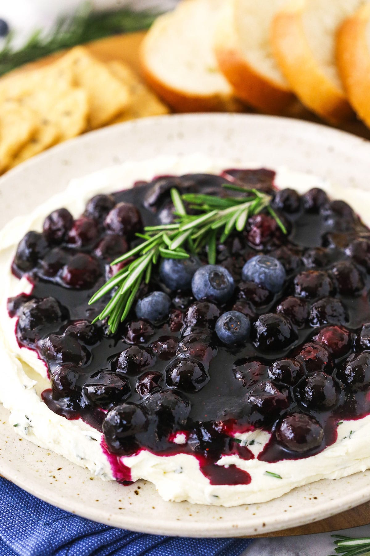 Rosemary berry cheese dip on a plate with a spotted kitchen towel underneath it