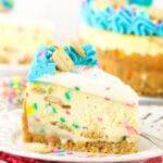 A piece of Dunkaroos cheesecake on a dessert plate with the remaining cake in the background