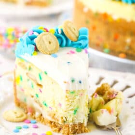 A slice of Dunkaroos cheesecake on a plate with one bite on a fork