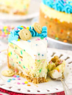 A slice of Dunkaroos cheesecake on a plate with one bite on a fork