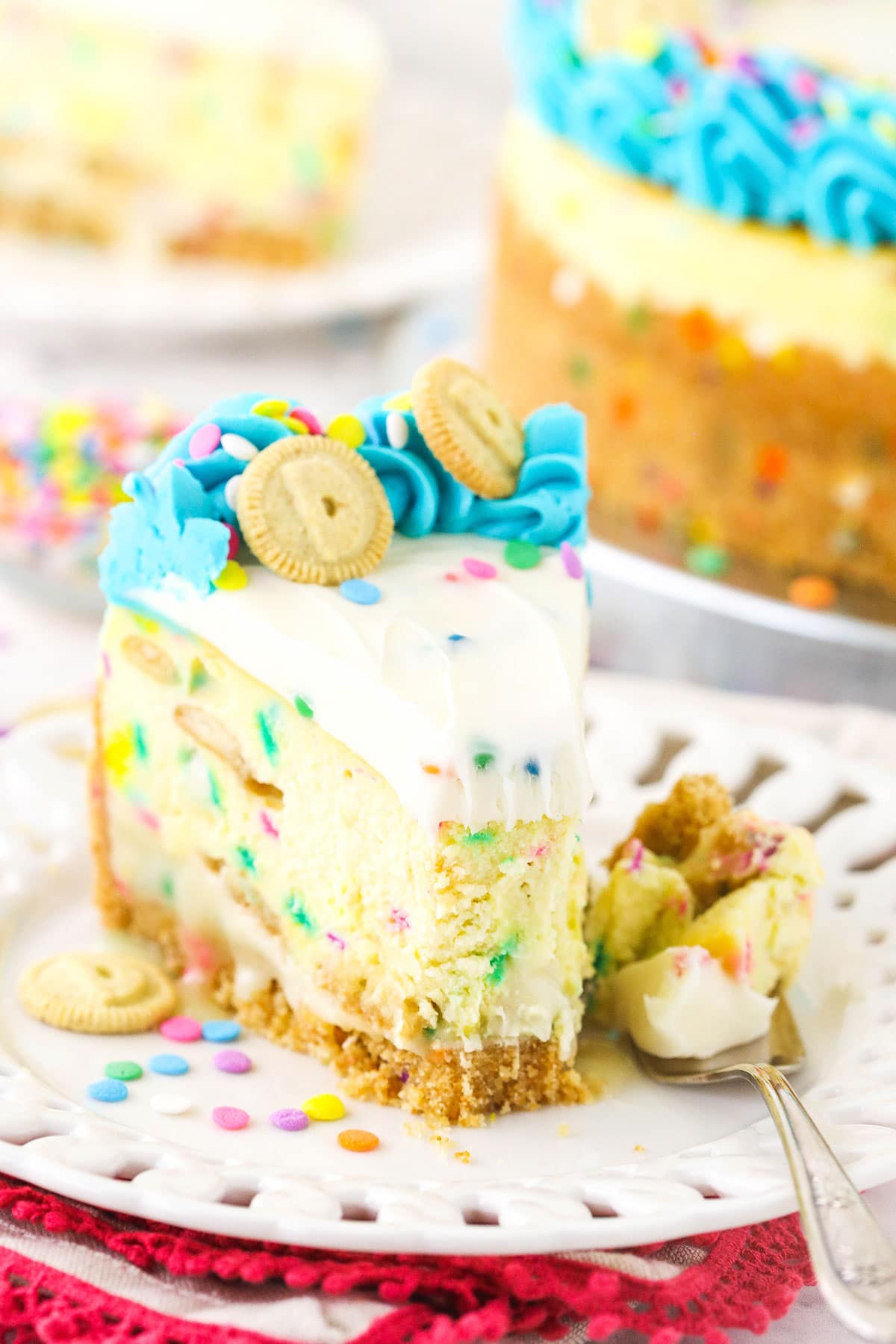 A slice of Dunkaroos cheesecake on a plate with one bite on a fork