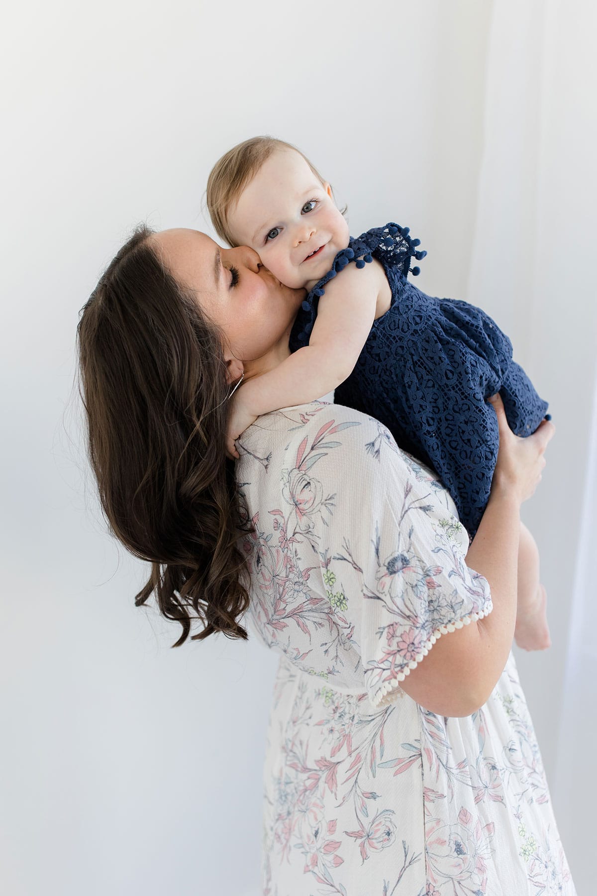 Lindsay holding McKenzie up and kissing her cheek