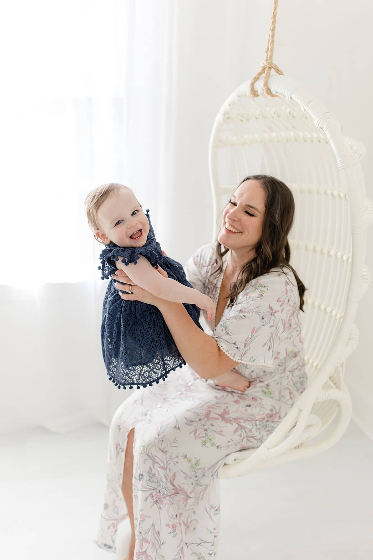 Lindsay holding McKenzie in the swing chair