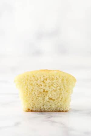 A moist vanilla cupcake cut in half to reveal its interior
