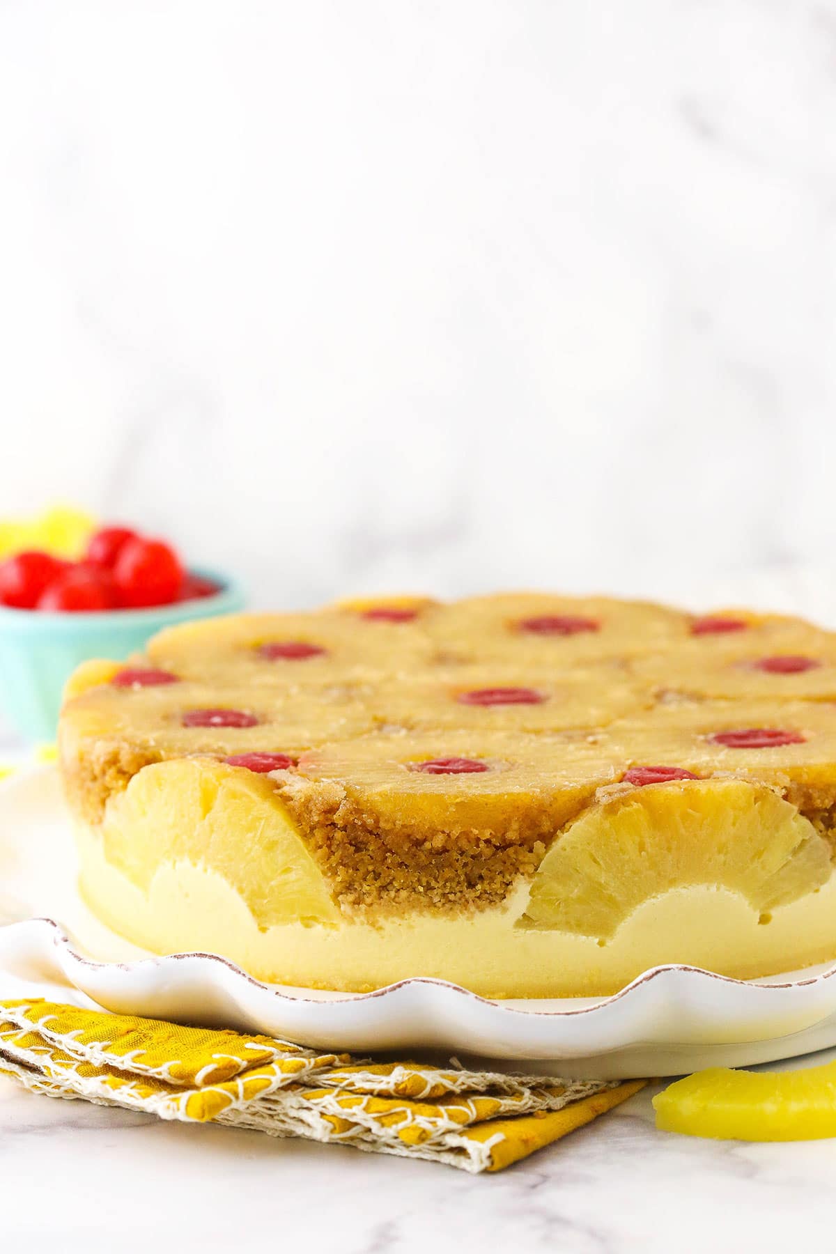 Side view of a pineapple cheesecake, showing the decorated sides.