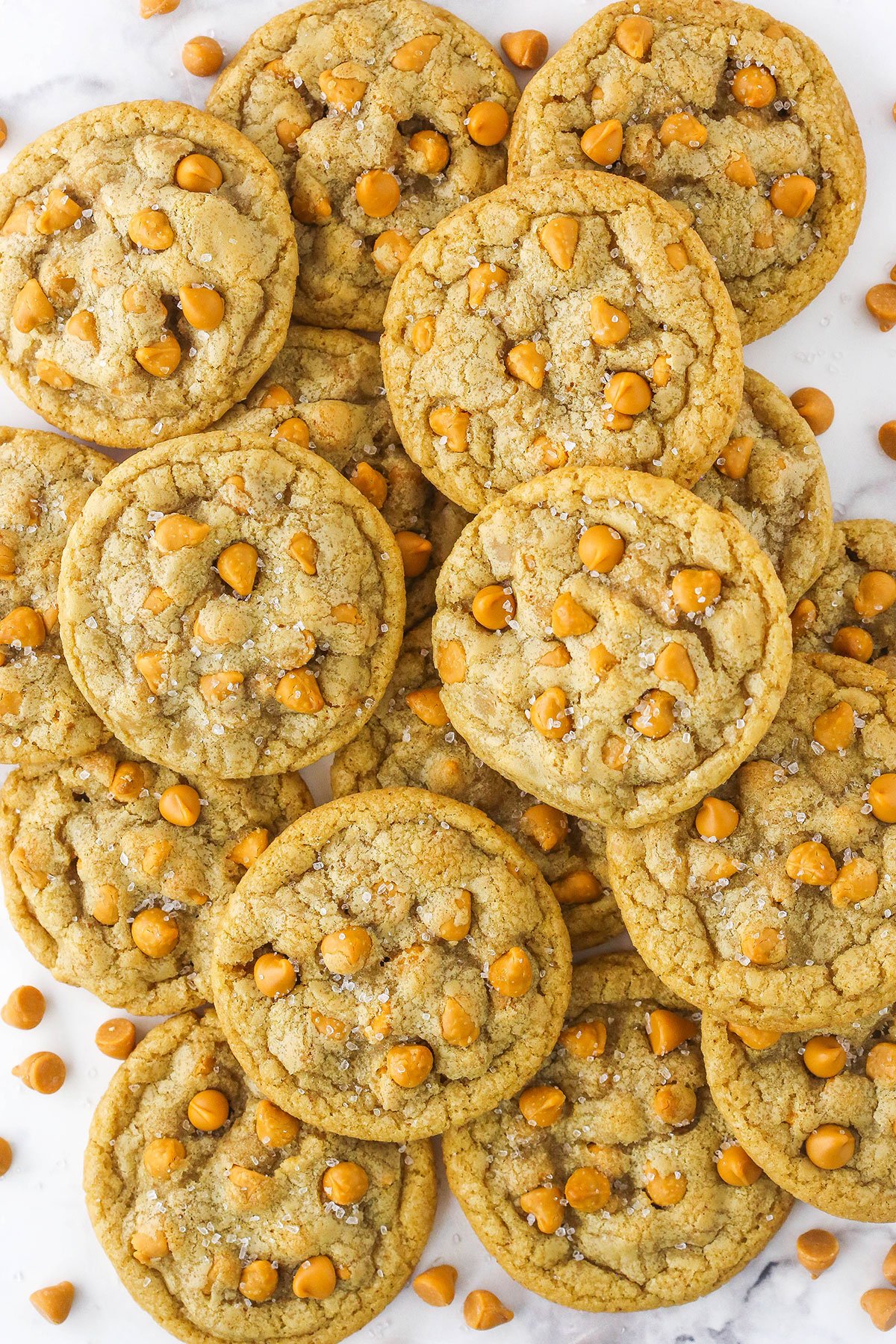 lots of butterscotch cookies piled onto white countertop