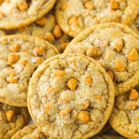 Close up of salted butterscotch cookies piled on a white countertop.