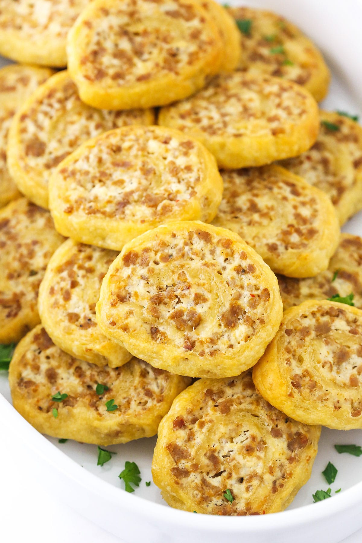 A close-up shot of sausage cream cheese crescent rolls piled into a large baking dish