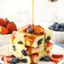 Three oven-baked flapjacks with pure maple syrup being poured over them