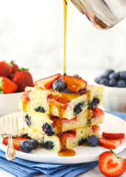 Three oven-baked flapjacks with pure maple syrup being poured over them