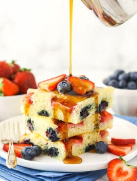 Three oven-baked flapjacks with pure maple syrup being poured over them