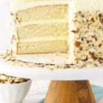 almond creamcake on cake stand with slice of cake removed