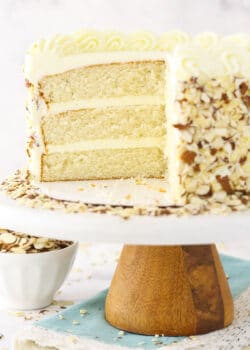 almond creamcake on cake stand with slice of cake removed