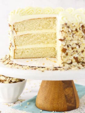 almond creamcake on cake stand with slice of cake removed