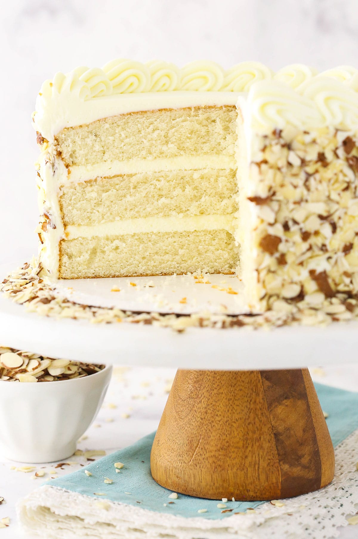 almond creamcake on cake stand with slice of cake removed