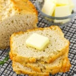 A slice of beer bread on a cooling rack with a pat of butter on top