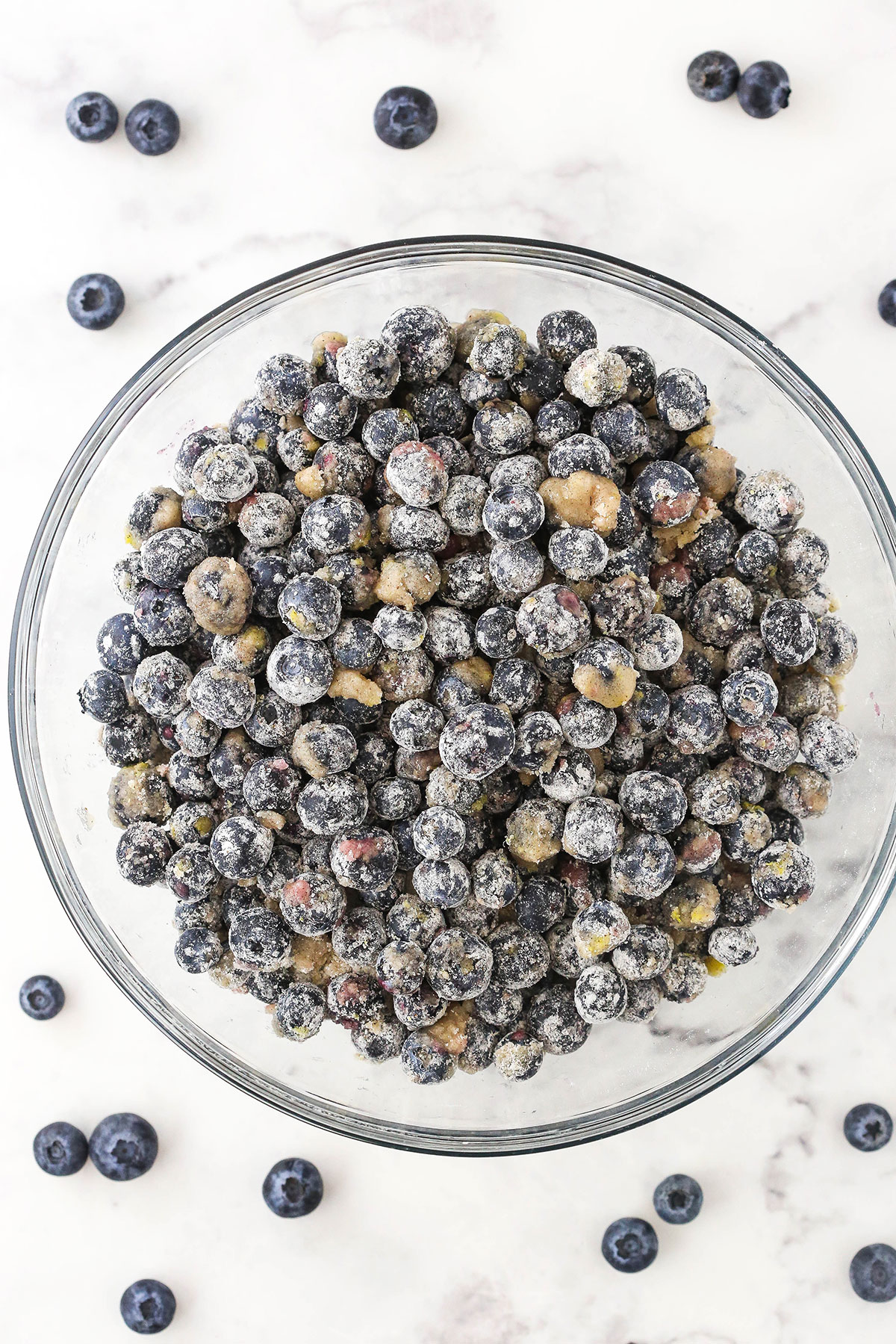 A bowl of fresh blueberries coated with a sugar and cornstarch mixture