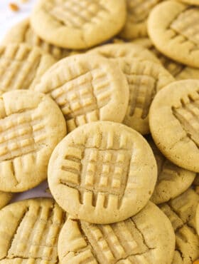 A bunch of homemade peanut butter cookies piled on top of one another