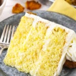 A slice of pineapple layer cake on a plate with the remaining cake behind it