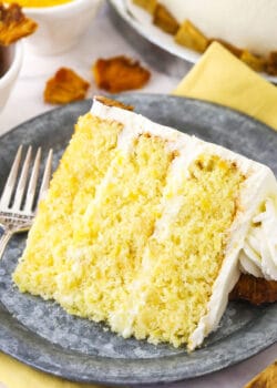 A slice of pineapple layer cake on a plate with the remaining cake behind it