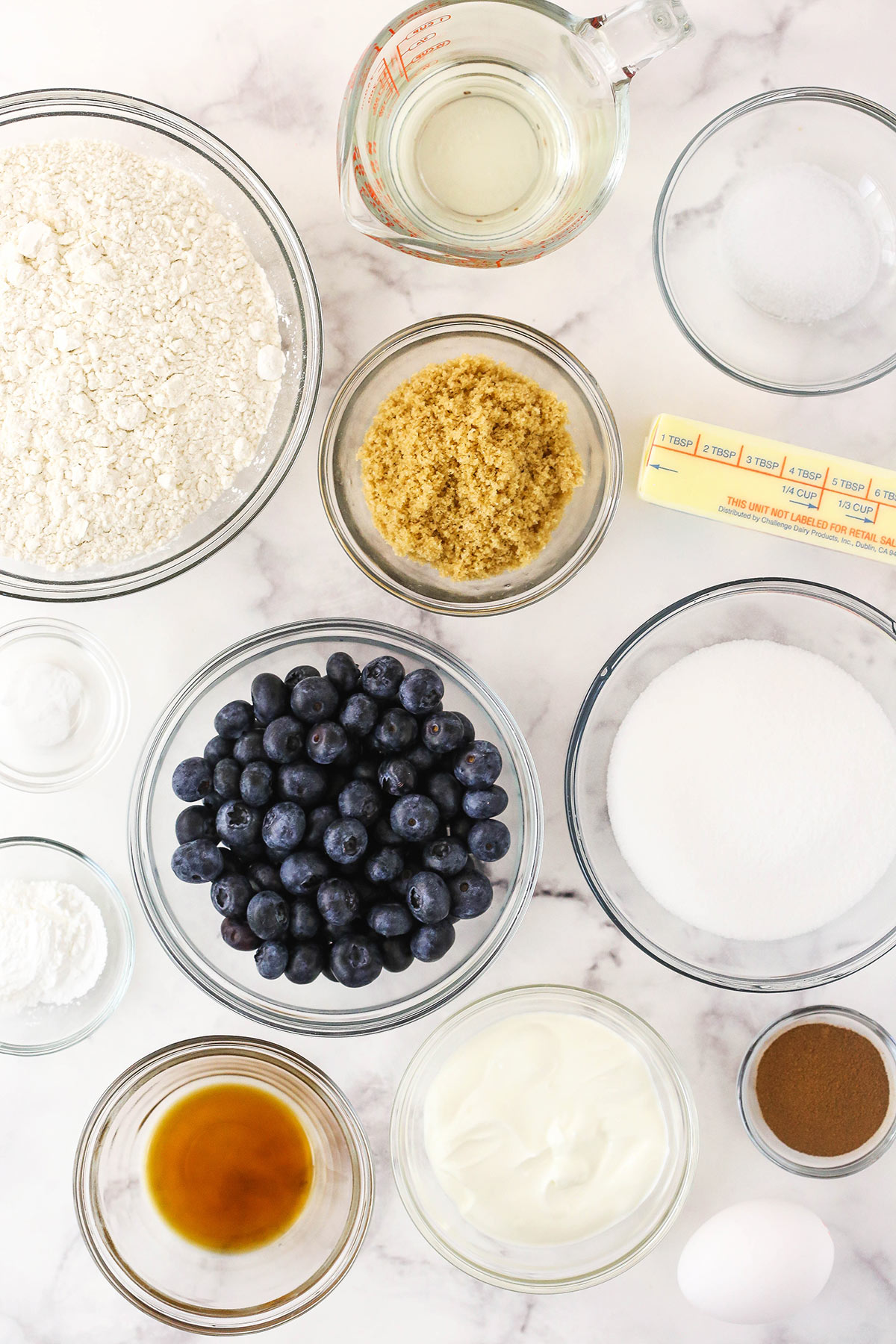 Brown sugar, vanilla extract, all-purpose flour, sour cream and the rest of the muffin ingredients on top of a marble counter