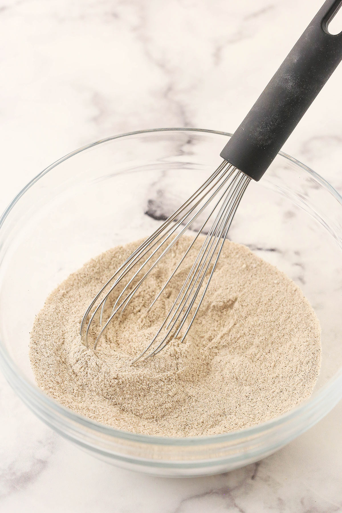 A whisk being used to combine the dry ingredients for the cinnamon streusel