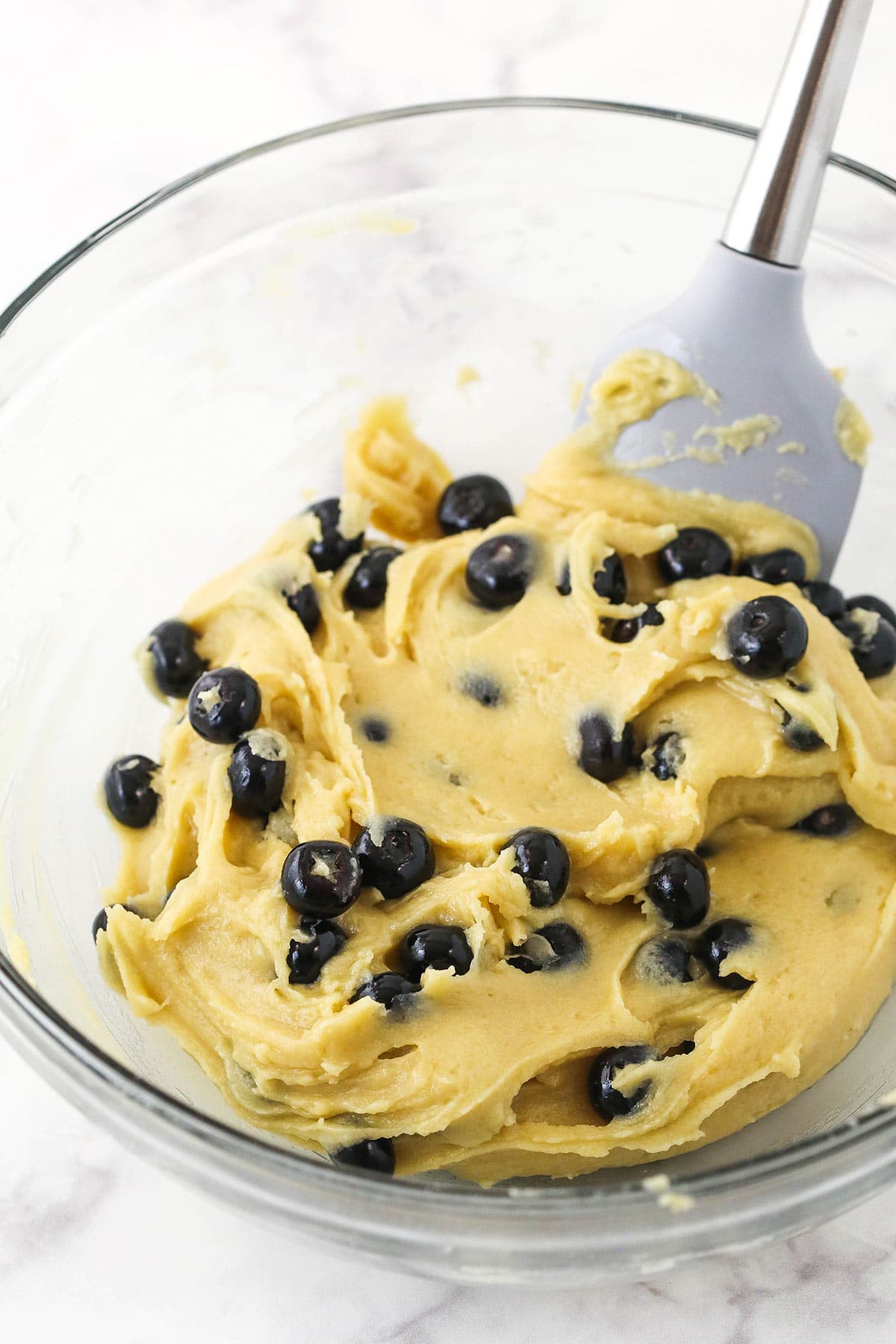 The finished batter inside of a large glass mixing bowl