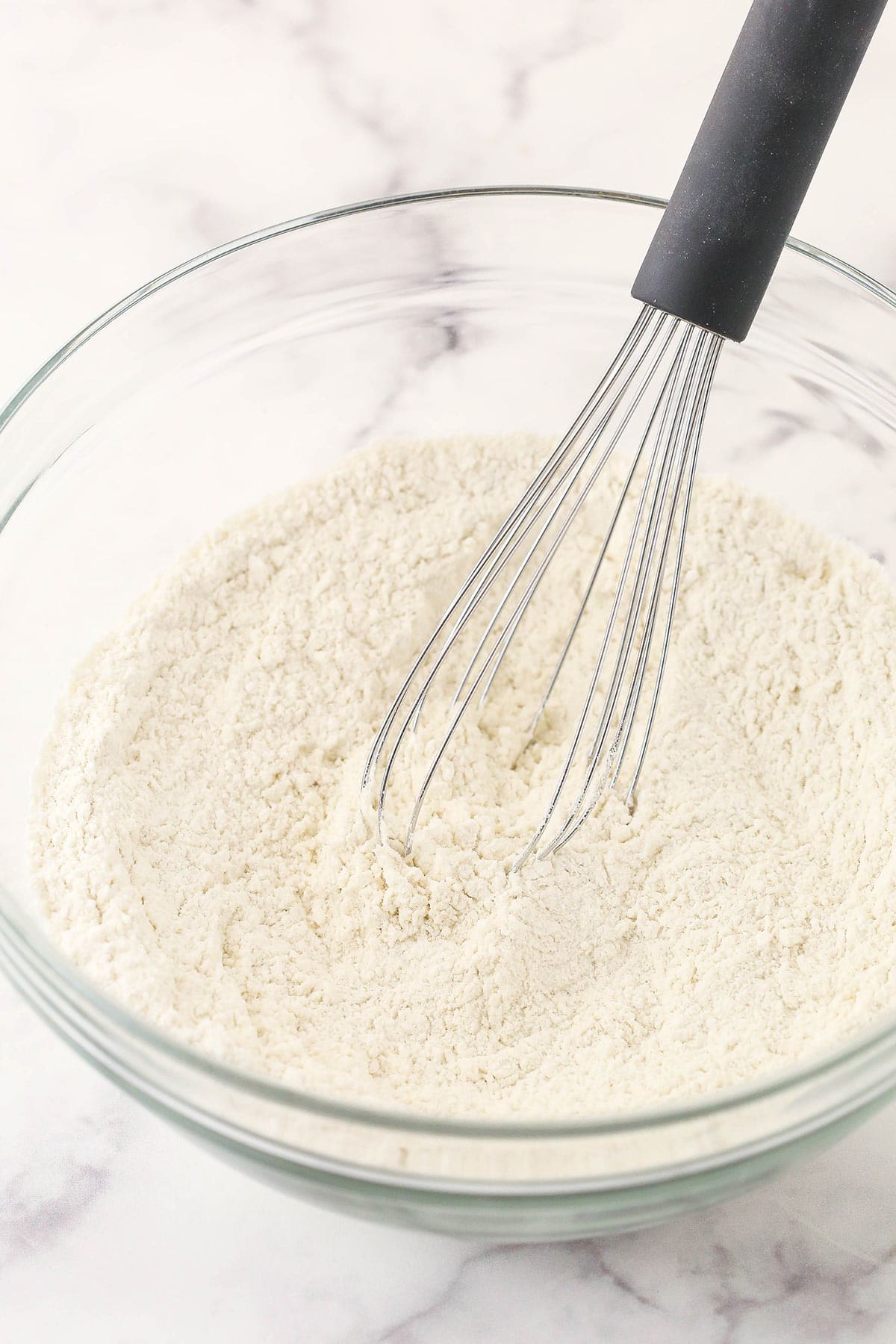 The combined dry ingredients inside of a bowl on a marble surface