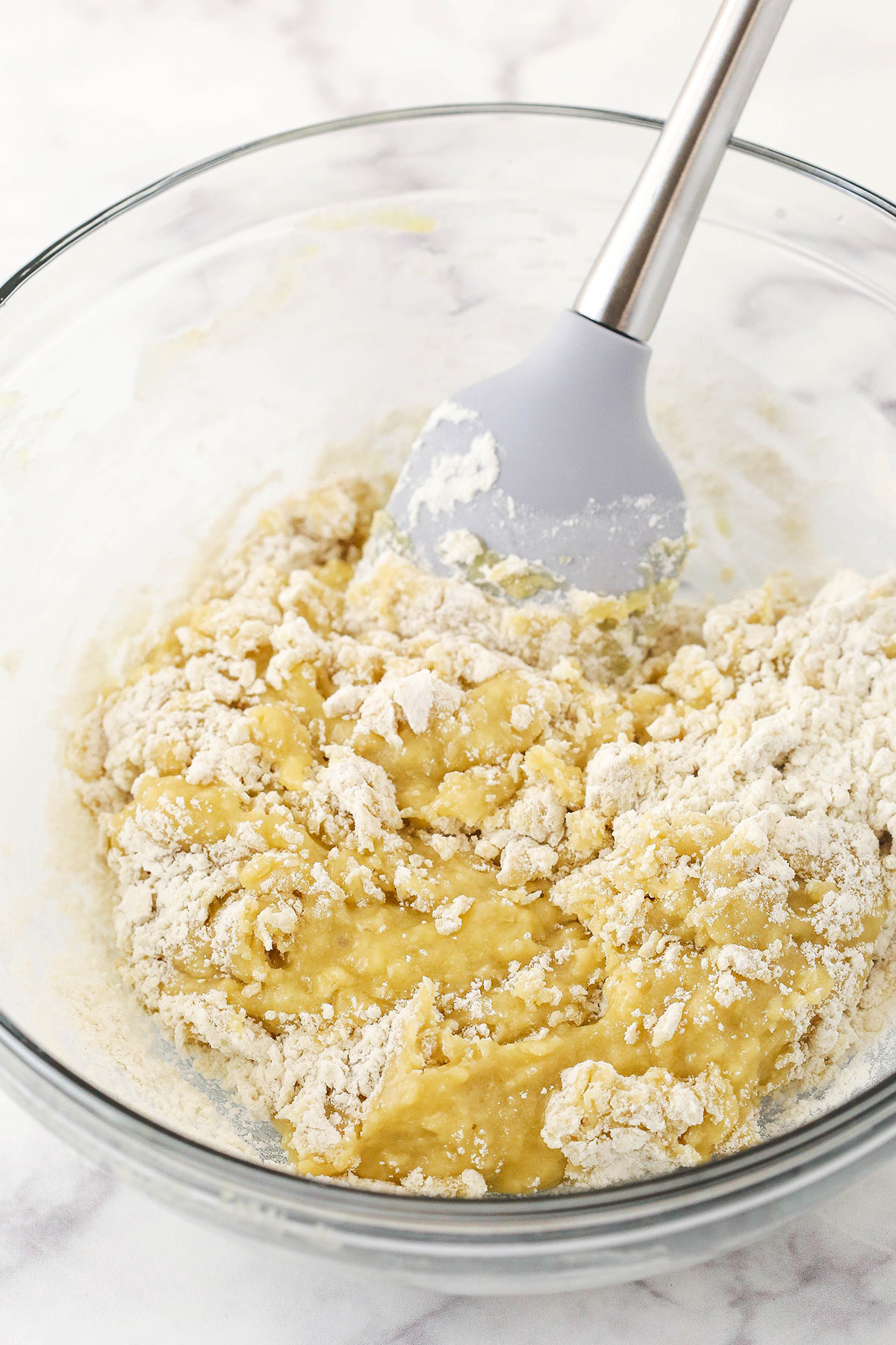 A spatula being used to combine the dry ingredients with the wet ingredients