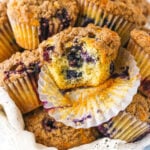 An unwrapped blueberry muffin with a large bite taken out of it