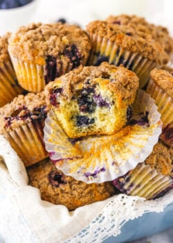 An unwrapped blueberry muffin with a large bite taken out of it