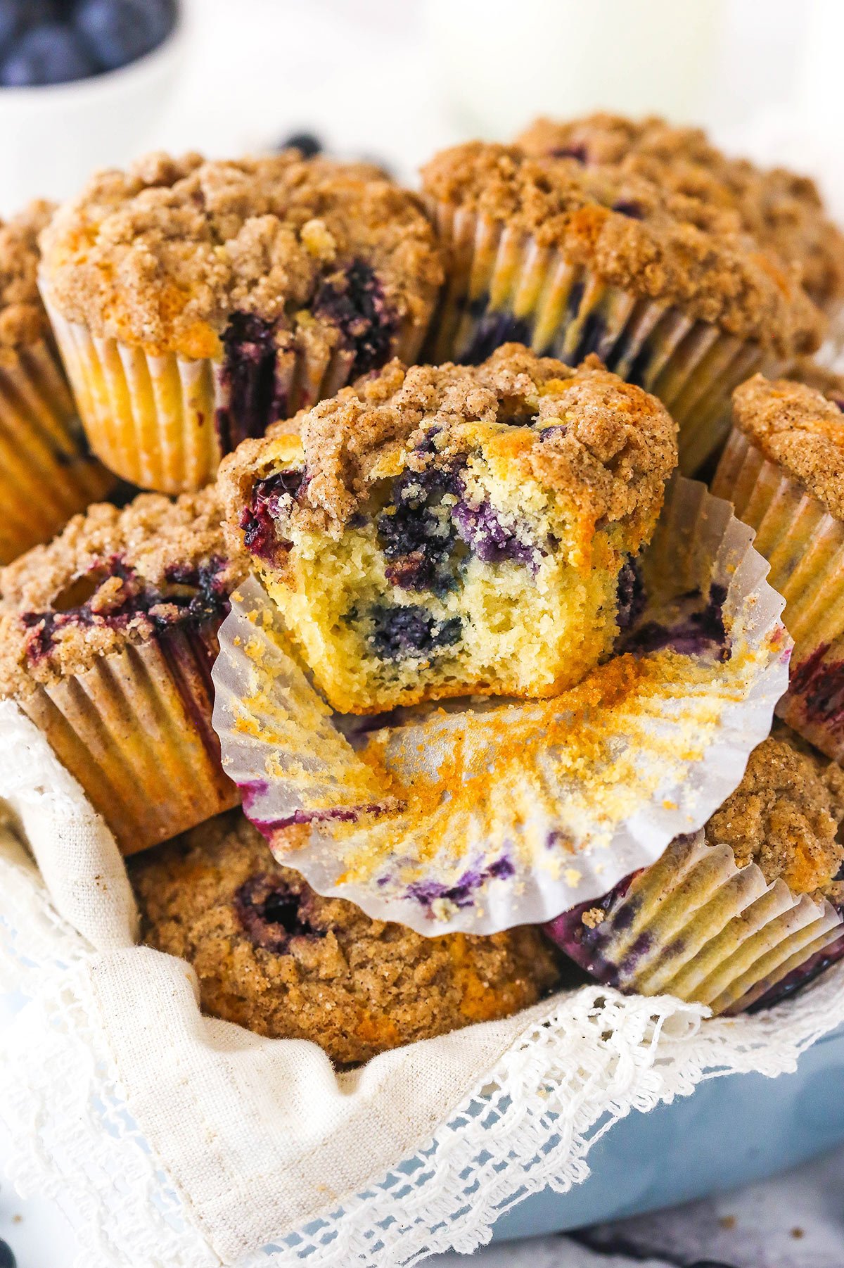 An unwrapped blueberry muffin with a large bite taken out of it